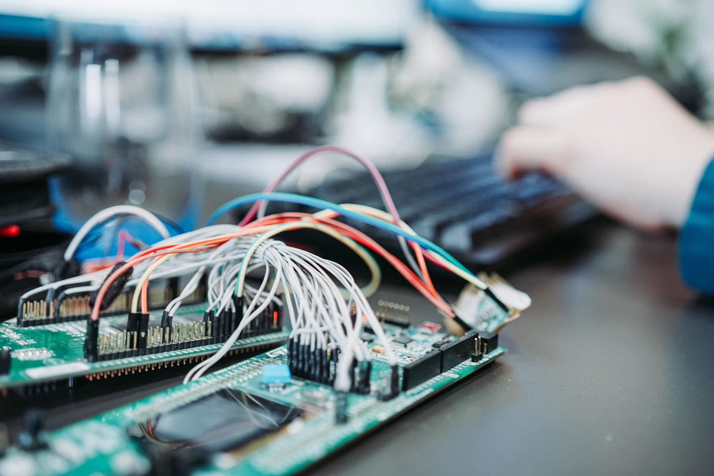 An electronics development board with dense wiring on a workbench.